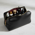 Luxury black vegan leather travel toiletry bag with gold zipper and organized interior