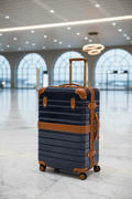 Luxury navy hardside carry-on suitcase with cognac leather trim and gold hardware